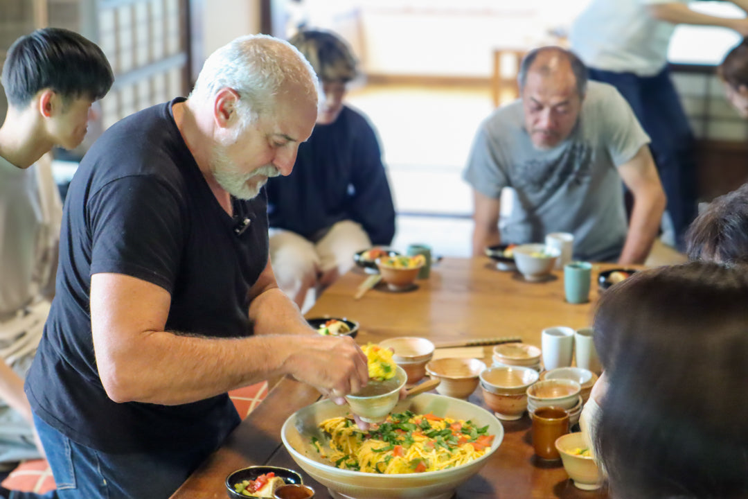 会員限定の食事会イベント。益子焼のうつわに大鉢から料理を取り分けている様子